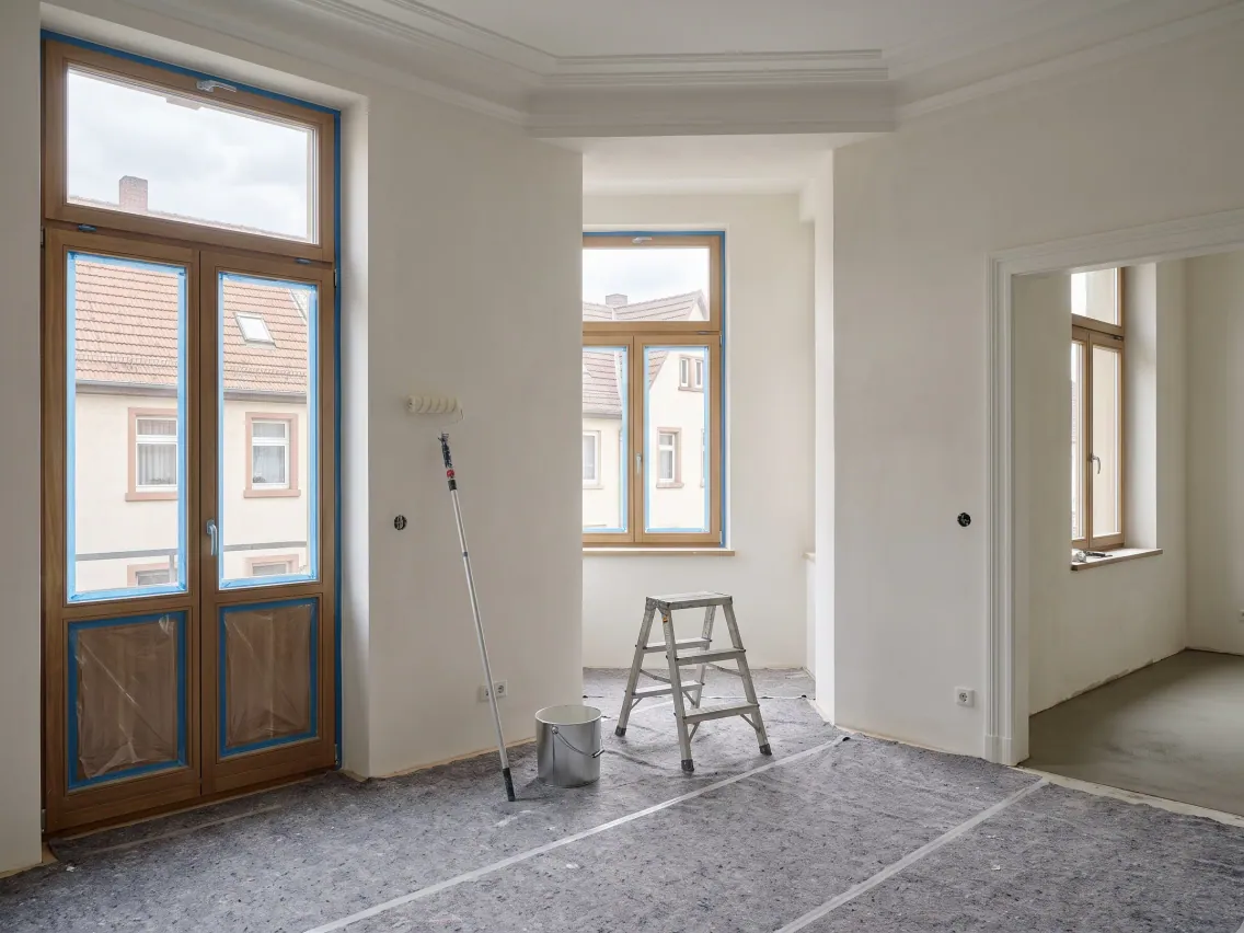 Altbausanierung: frisch verputzte Wände, abgeklebte Fenster, Malerwerkzeug